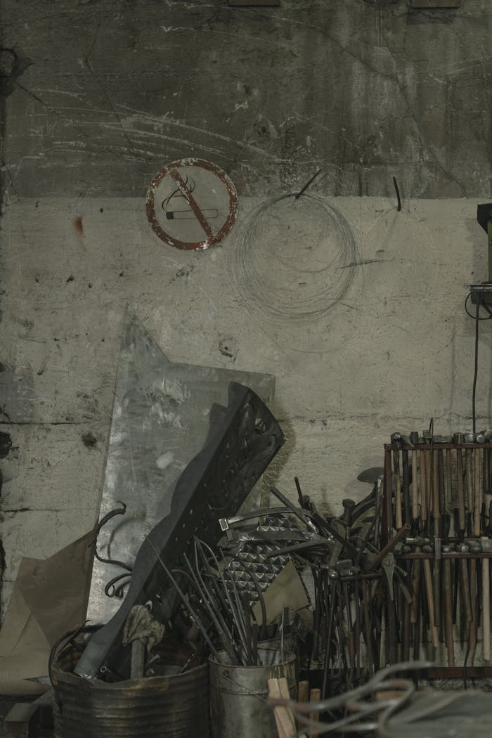 core-values A collection of metal scraps, tools, and steel components in a dimly lit warehouse corner.